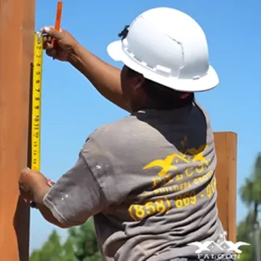 Construction Worker Measuring Wood by IO Builders Group in San Diego, CA