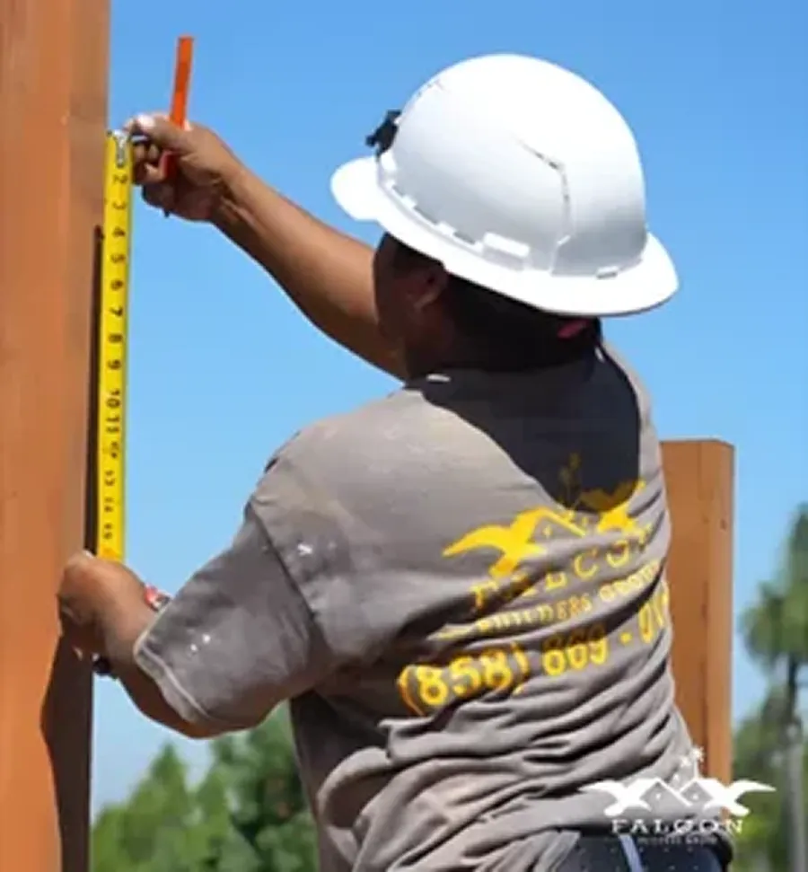 Construction Worker Measuring Wood by IO Builders Group in San Diego, CA
